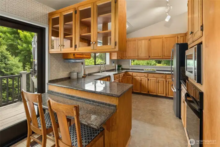 Kitchen with breakfast nook, views of the garden space, and door opening to deck. Kitchen with breakfast nook, views of the garden space, and door opening to deck.