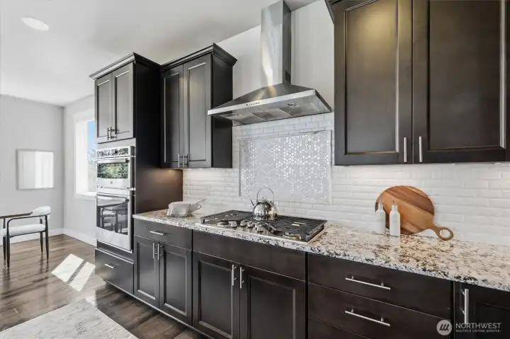 Kitchen featuring granite countertops, stainless steel appliances, and rich cabinetry.