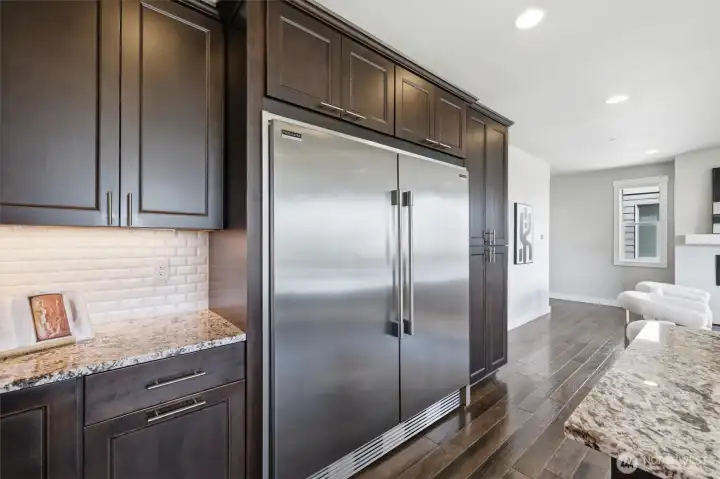 Ample kitchen storage with oversized refrigerator and walk-in pantry access.