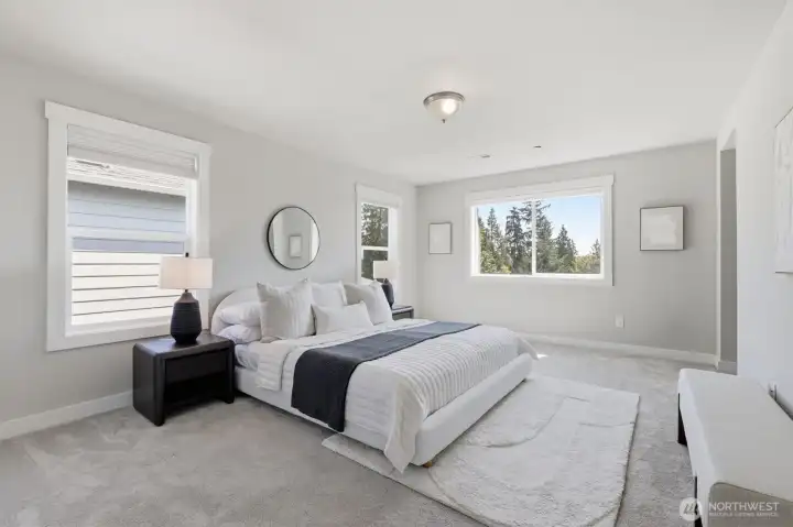 Bright primary bedroom with large windows.