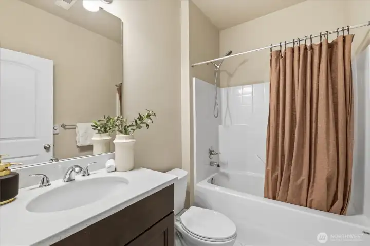 Full guest bathroom with vanity and tub/shower combination.