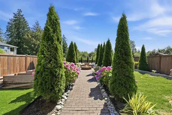 Fully fenced backyard with lush lawn and mature landscaping.