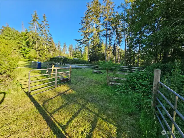 Large fenced area to the right for livestock.