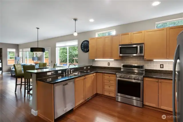 Great kitchen space with stainless steel appliances, granite countertop, full backsplash and breakfast bar.