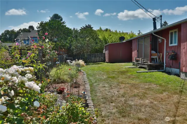 Side yard is partially fenced for pets and garden protection.