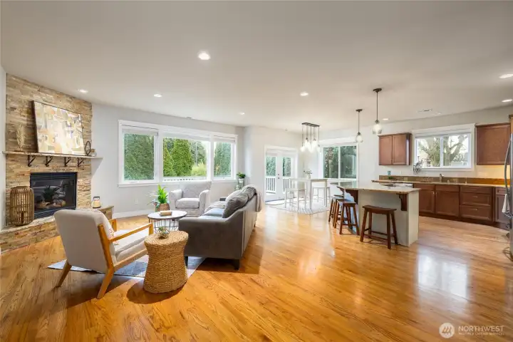 Warm and welcoming real oak floors and a stone-surround gas fireplace help turn this great room style living area into the heart of the home.