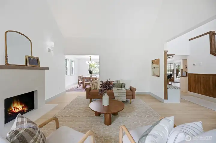 Just inside the entry, the inviting family room is filled with natural light and enhanced by soaring vaulted ceilings. A cozy gas fireplace anchors the space, while the open layout flows seamlessly into the dining area—ideal for everyday living and entertaining.