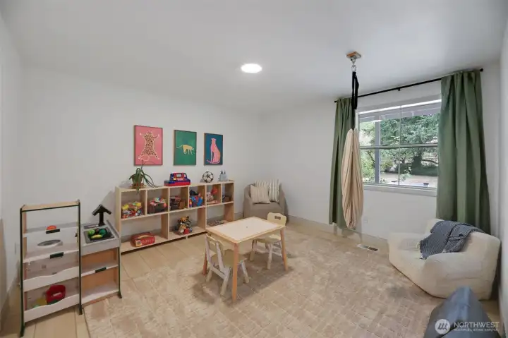 Spacious main-level bonus room, perfect as a game room, playroom, or flexible living space. Ideal for a main-level primary suite, with an existing bathroom just off to the right (not shown) and potential to reconfigure into a private full ensuite.