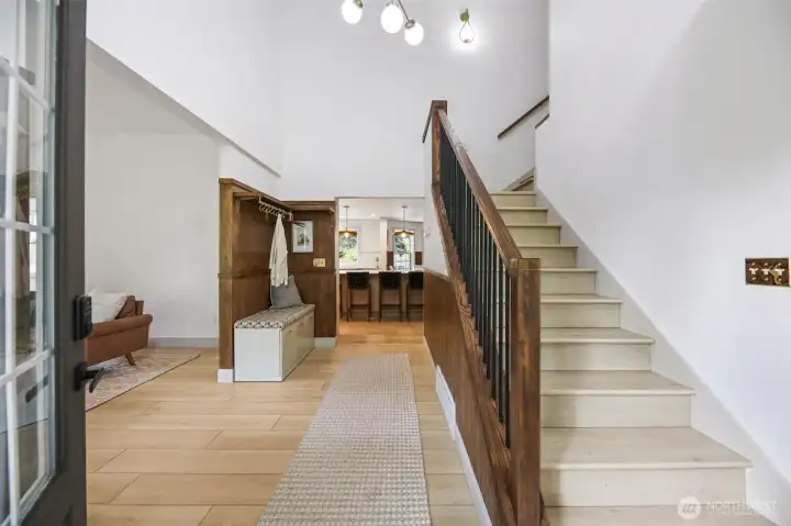 The main staircase from the entry leads to the upper level, where a thoughtfully designed layout offers spacious bedrooms, updated baths, and flexible living areas—setting the stage for the next level of comfort and privacy.