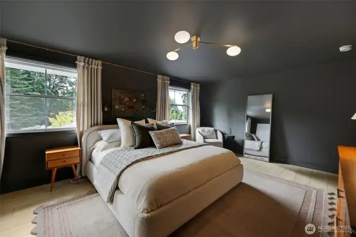 Large windows frame peaceful views of the private, lush backyard—bringing in natural light and a sense of calm to this serene retreat.