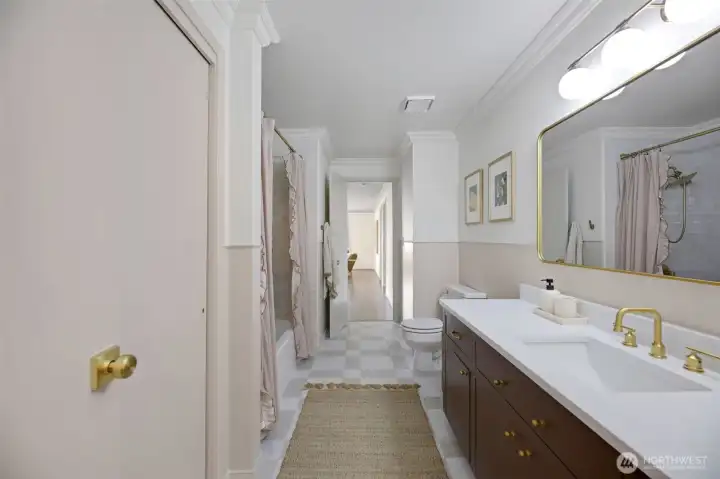 The opposite side of the bath provides a second access point to the “west wing,” offering flexible living options. With its generous size, the bathroom could be easily reconfigured into two separate baths—ideal for creating a dedicated bath for the additional living space.