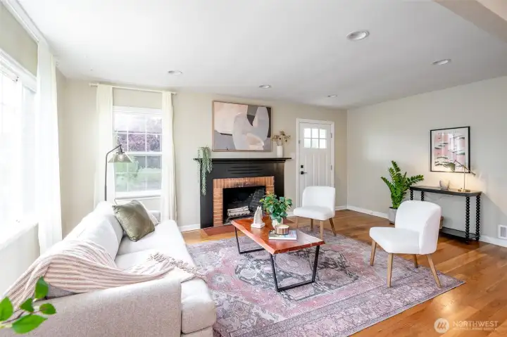 The beautiful living room features a striking fireplace, a room full of windows and warmth.