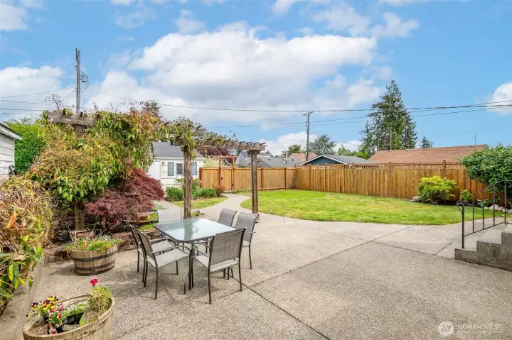 The expansive yard feels like a private retreat with mature landscaping, flowering plants, and low-maintenance greenery.