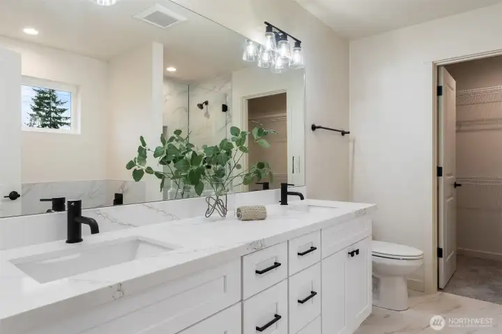 Dual undermount sinks and quartz countertops in Primary Bathroom.