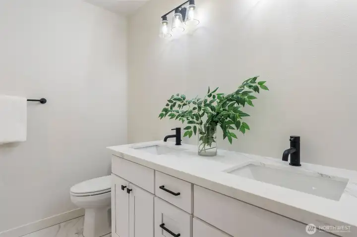 Main Bathroom has quartz counters with undermount sinks and tile flooring.