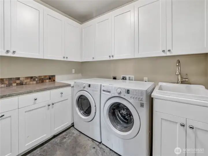 Detached ALU laundry room with abundant cabinet storage.