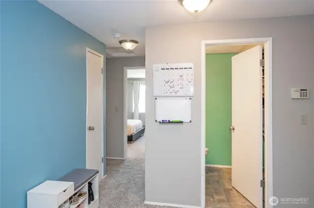 The half bath and utility room are just through the door on the right, while the hallway to the left leads to the bedrooms.
