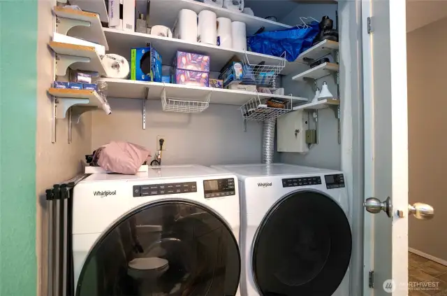 Tucked behind the door in the half bath is the utility room, complete with extra shelving for added storage.