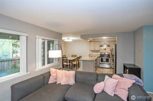The living area offers a seamless view into the kitchen and dining spaces, highlighting the home’s open-concept layout and effortless flow.