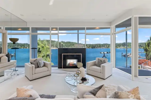 Framed by two stories of floor-to-ceiling glass, the living room is a front-row seat to Wollochet Bay’s ever-changing beauty. Crisp modern lines, mirrored accents, and a striking black granite fireplace with jeweled inlay create an atmosphere that is both glamorous and inviting.