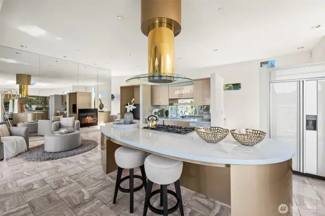 A statement kitchen in every way with Subzero and Miele appliances, marble counters, lucite cabinets, and marble floors.