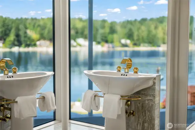 These dual pedestal sinks backed in marble tile pair timeless elegance with panoramic views.