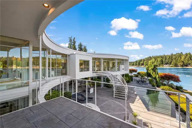 This large private stamped concrete deck off the primary suite gives you the bird's eye view of the stunning architecture surrounding the courtyard, infinity pool, and 180 degree views of Wollochet Bay.