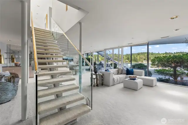 By this point in the tour you expect nothing less... of course the floating staircase has gold ribbon running through the railings that descend to the lower level recreation area and guest bedrooms.