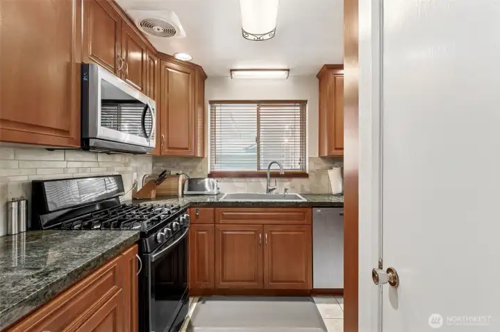 Kitchen - custom wood cabinets, granite tile counters, and gas range!