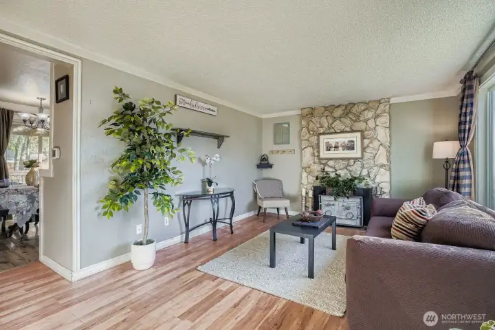 Large picture window in living room allows for great natural light & cozy fireplace insert will bring the warmth. Slate hearth, decorative floor to ceiling rock mantle, laminate wood flooring & crown molding