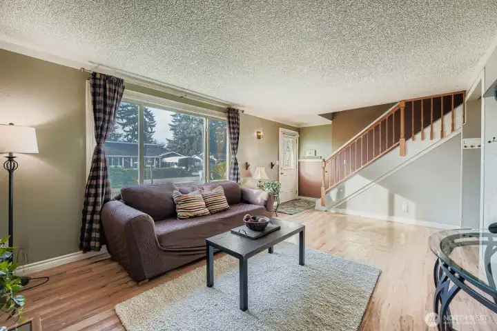 View of entry & carpeted stairway with wood railing, chair rail and chair rail wainscoting that leads to the 2nd floor where all rooms have ceiling fans, some 6 panel doors & two linen closets- one is walk-in/good sized and where you'll find the attic access