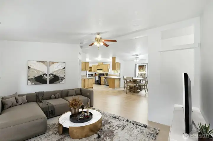 Virtually staged living area illustrating a bright, open layout with open-concept and all new oak engineered hardwood flooring.