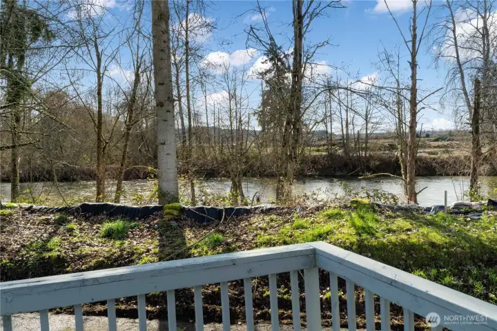 Enjoy outdoor living on the spacious deck overlooking the calm river and surrounding nature.
