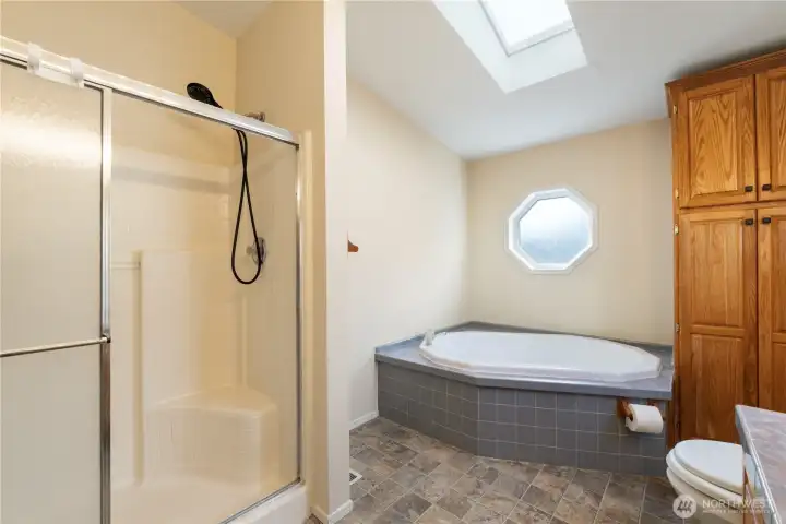 This five-piece bathroom combines a deep soaking tub and walk-in shower with bright finishes and generous counter space, creating a calm and practical retreat.