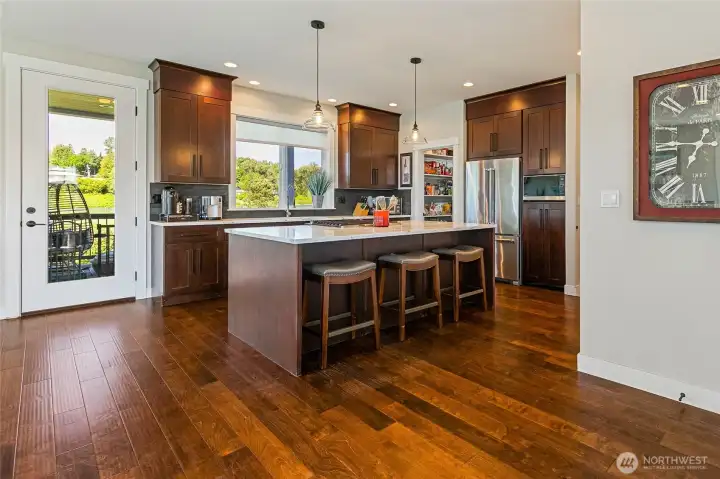 The gorgeous kitchen welcomes you including large island with bar seating and pendant lighting. The gorgeous kitchen welcomes you including large island with bar seating and pendant lighting.