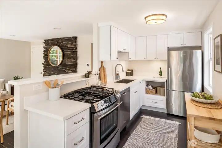 Recently updated kitchen features gas range with downdraft venting, and a Fisher & Paykel fridge.