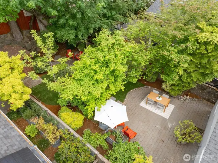 Enjoy the peaceful retreat of the backyard with a patio, grass, mature trees, planters for flowers and veggies and a garden shed or playhouse.