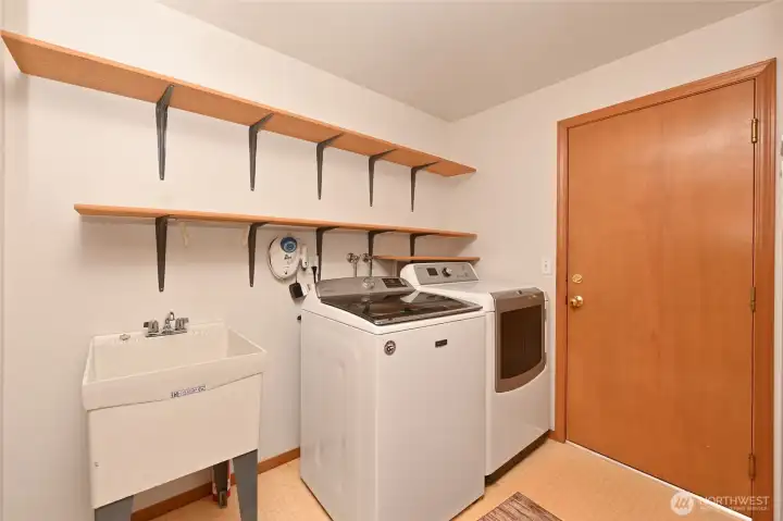 Laundry room with utility sink, entrance to the garage Laundry room with utility sink, entrance to the garage