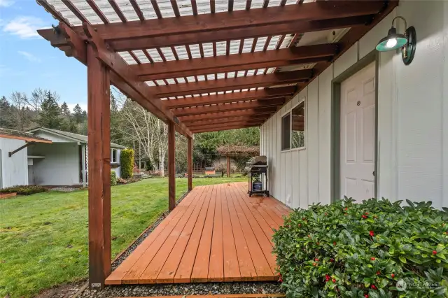 Partially covered wrap around deck with entrance to utility/mud room