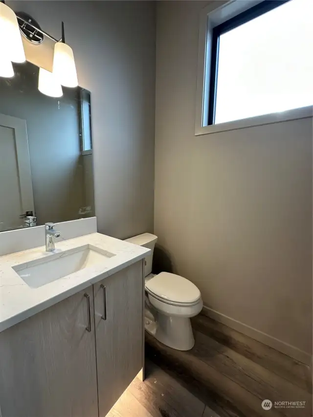 Half bath in flex space also features quartz counter, motion activated toe kick lighting and large window for lots of light.