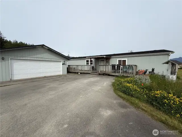 Front garden area and covered front porch with large deck and a hot tub