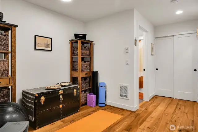 View to the hallway, workout space, bathroom, and utility closet on lower level.