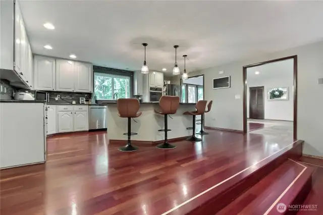 The spacious open kitchen boasts an island, granite counters, double ovens, and a beverage fridge; it’s a culinary enthusiast's paradise.