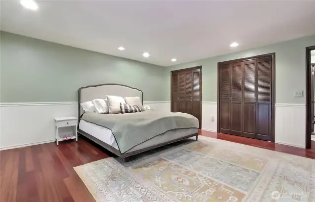 The primary suite features two-tone wainscoted walls and dual closets.