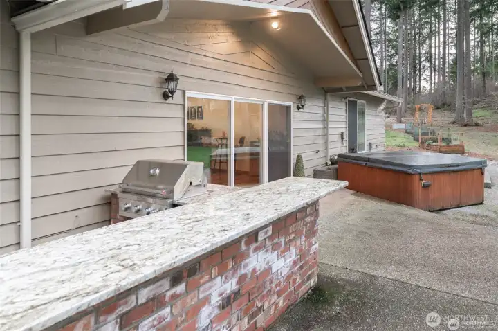 The outdoor space includes a multitude of features, including a barbecue kitchen area.