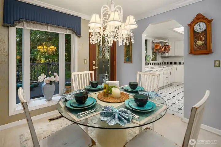 Enjoy an intimate dining experience surrounded by soft natural light and lush greenery just beyond the glass doors. The sparkling chandelier, designer wall treatment, and gold accents create an inviting ambiance perfect for both casual dinners and special occasions.