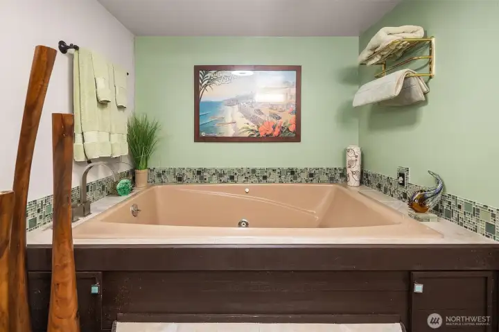 Unwind in the spacious soaking tub surrounded by decorative mosaic tile and serene green tones. Thoughtful details—like modern fixtures, ample storage, and soft lighting—make this bath a rejuvenating space for guests or everyday relaxation. ????
