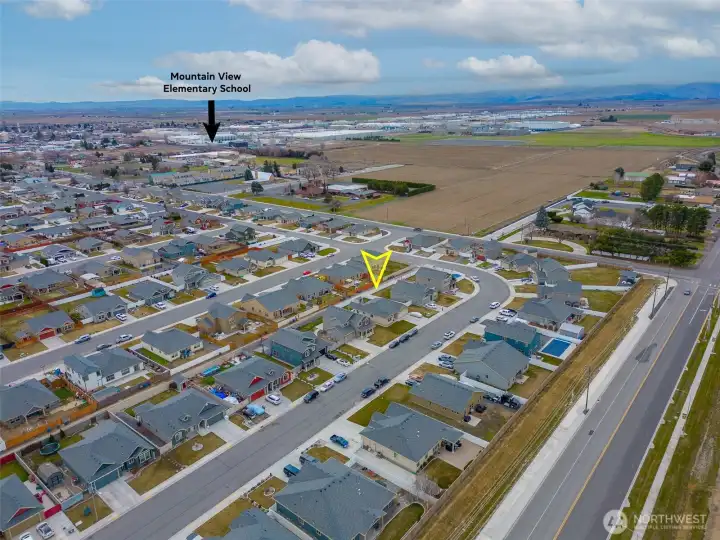 AERIAL VIEW LOOKING SOUTHWEST: Home Sits on a Bend in the Road to the West, Naturally Slowing Traffic; Nearby School Visible to the Southwest