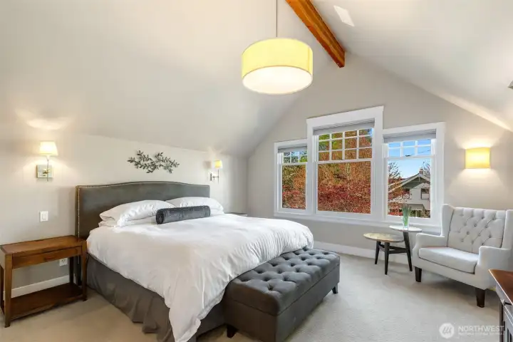 Primary suite with vaulted ceilings and large windows.