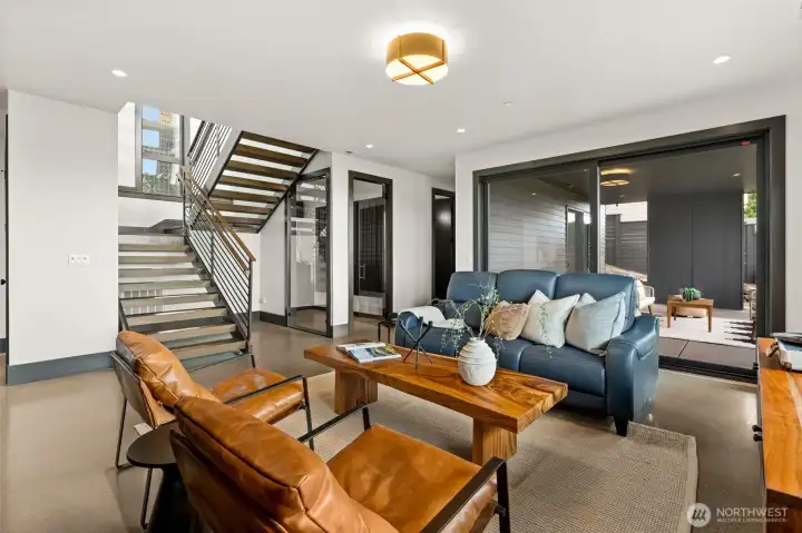Comfortable living space with modern finishes, open stair design, and seamless access to covered outdoor area for easy indoor-outdoor living.